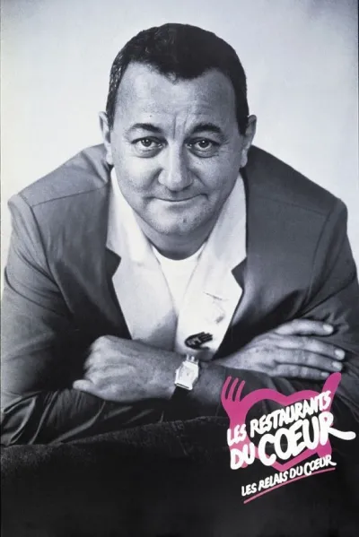 Photo de Coluche en noir et blanc avec le logo ''Les Restaurants du coeur''
    en bas à droite de l'image.